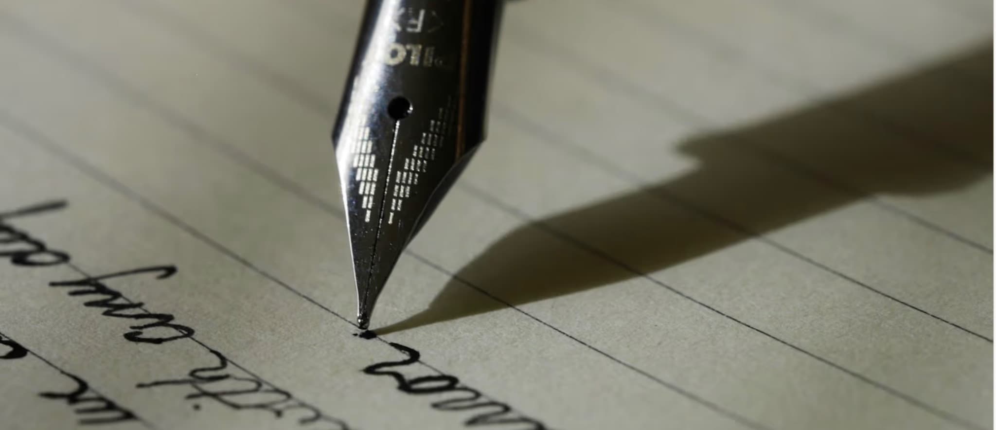 Plume écrivant sur une page manuscrite